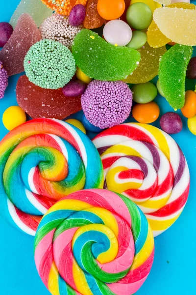 色彩斑斓的棒棒糖和不同颜色的圆形糖果 顶部视图 — 图库照片