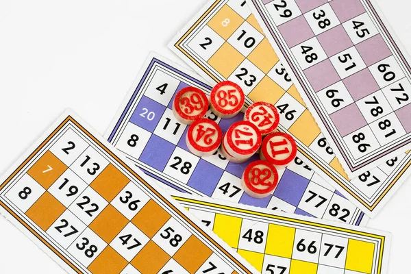 Colorful bingo game cards and numbers on white background, close up, isolated.