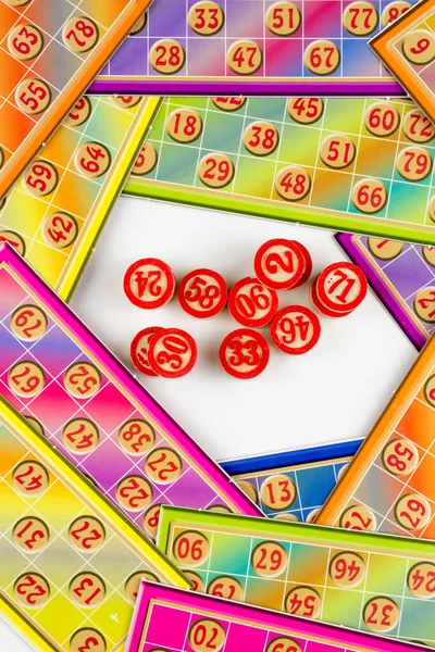 Colorful bingo game cards and numbers on white background, close up, isolated.