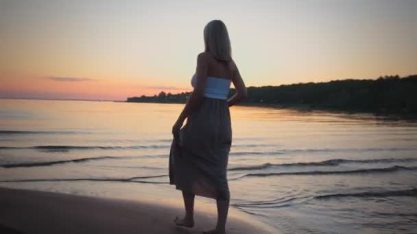 Bella silhouette ragazza incinta al tramonto va sulla spiaggia — Video Stock