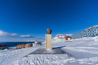 Landscape of the Russian city of Barentsburg on the Spitsbergen archipelago in the winter in the Arctic In sunny weather and blue sky clipart