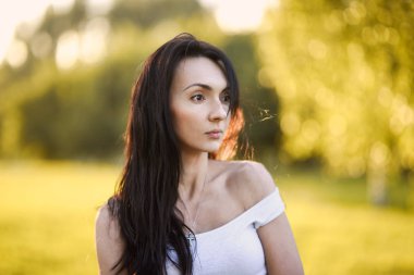 yakın çekim yeşil bir bahçe poz ve gülümseyen bir romantik esmer etek bir güzel şirin kız portresi