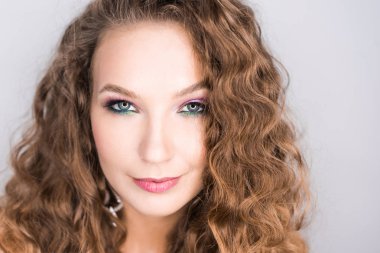 Portre Studio profesyonel makyaj ve açık diş gülümseme ile poz güzel sarışın kıvırcık kız