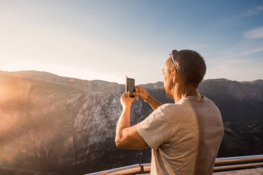 Norveç, selfie, özgürlük elinde tutan bir smartphone dağlar kjeragbolten kjerag taştan yakışıklı yaşlı adam için bir aşırı planı seyahat portresi