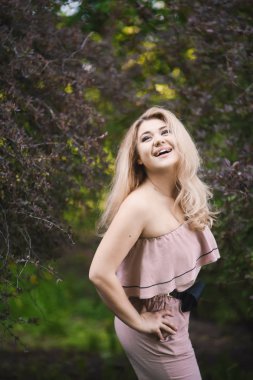 Portre güzel kabarık dudakları ve seksi kadınsı vücut yeşil parkta güneşli günde poz ile'deki genç sarışın kız 