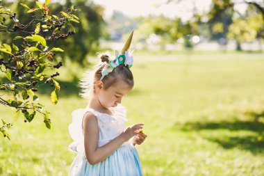bir romantik mavi elbiseli şirin ile Bahçe park güneşli gün gülümseyerek unicorn ile Cadılar Bayramı kutlamak bir yeşil sonbaharda güzel bir kızın yakın çekim portre