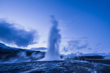 İzlanda'daki Strokkur şofben erüpsiyon. Kış soğuk renkler, gece boyunca Buhar Aydınlatma ay 