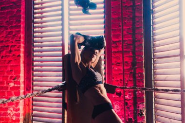 Fitness egzersiz kavramı arka plan - kas vücut geliştirmeci seksi spor kız Gym salonunda boks eldivenleri egzersizleri yapıyor eğitim gücü