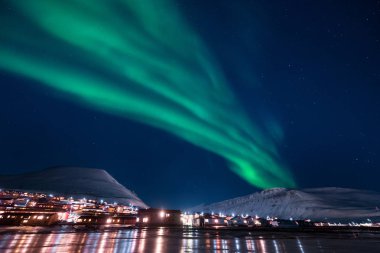 The polar arctic Northern lights aurora borealis sky star in Norway Svalbard in Longyearbyen the moon mountains clipart
