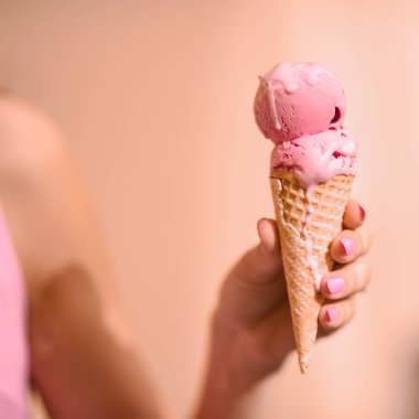 yakın çekim bir gözleme dondurma boynuz yalıyor tutan pembe elbise ve yaşam tarzı gülümseyen puffs kıvırcık saçlı Genç güzel seksi kız portresi