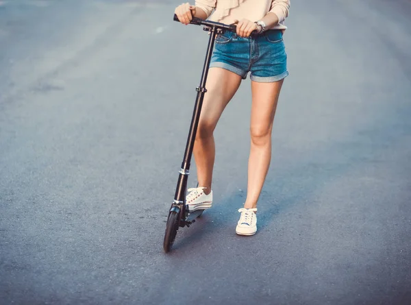 Piękna Młoda Dziewczyna Szorty Jeansowe Jazdy Skuterem Elektrycznym Okulary Przeciwsłoneczne — Zdjęcie stockowe