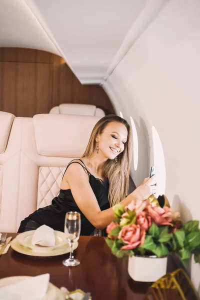 Gyönyörű Fiatal Lány Kabinban Egy Üzleti Osztályú Repülőgép Egy Telefon — Stock Fotó