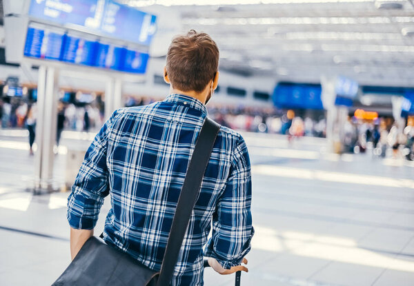 Европейский ботаник из аэропорта в очках и клетчатой рубашке с багажным туристическим самолетом, летящим в маске для лица. Вирусы коронавируса гриппа 