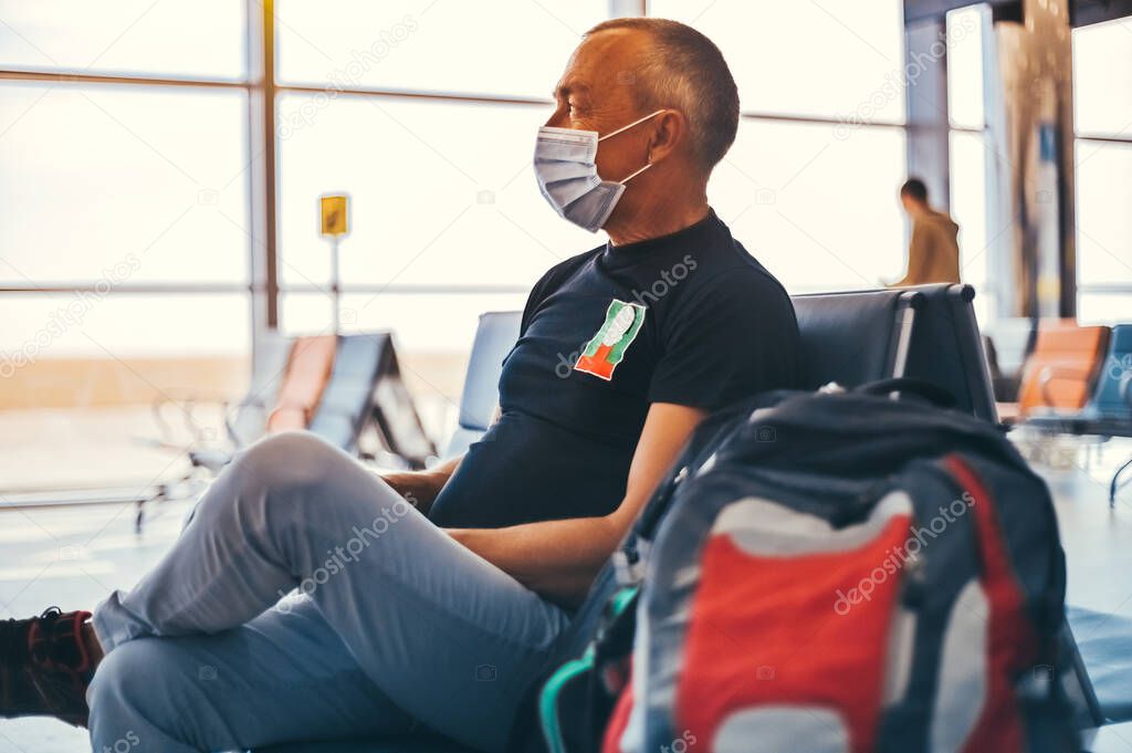 Airport attractive old man tourist boarding plane taking a flight  wearing face mask. Coronavirus flu virus travel concept banner panorama.