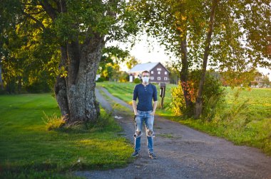 Gün batımında parkta uzun kollu gözlüklü ve koruyucu maskeli çekici inek portresi.