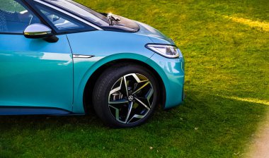 Tnsberg, Norveç - SEPT 17, 2020: gök mavisi VOLKSWAGEN VW I.D.3, MEB platformuna dayalı kompakt C segment elektrikli otomobil. Güneşli bir günde yeni bir araba. Covid19 sırasında maske takan inek bir adam.. 