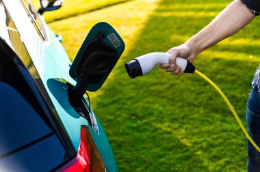 Tnsberg, Norveç - SEPT 17, 2020: gök mavisi VOLKSWAGEN VW I.D.3, MEB platformuna dayalı kompakt C segment elektrikli otomobil. Güneşli bir günde yeni bir araba. Covid19 sırasında maske takan inek bir adam.. 