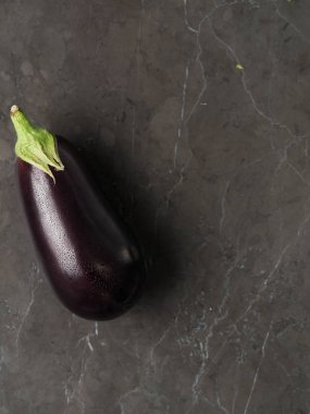 Su ile güzel taze patlıcan mermer bir zemin üzerine bırakır. Dikey yüksek çözünürlüklü fotoğraf