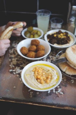 Bir İsrail Kudüs İsrail'in Cafe'de yemek. Bir tabak, Bütün cheakpeas, pide ve turşu arka planda yığını ile kremsi humus Falafels