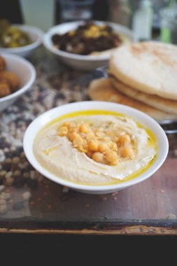Bir İsrail Kudüs İsrail'in Cafe'de yemek. Bir tabak, Bütün cheakpeas, pide ve turşu arka planda yığını ile kremsi humus Falafels