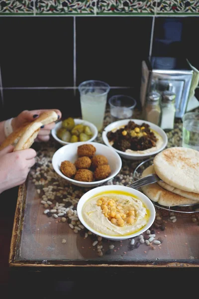 Bir İsrail Kudüs İsrail'in Cafe'de yemek. Bir tabak, Bütün cheakpeas, pide ve turşu arka planda yığını ile kremsi humus Falafels