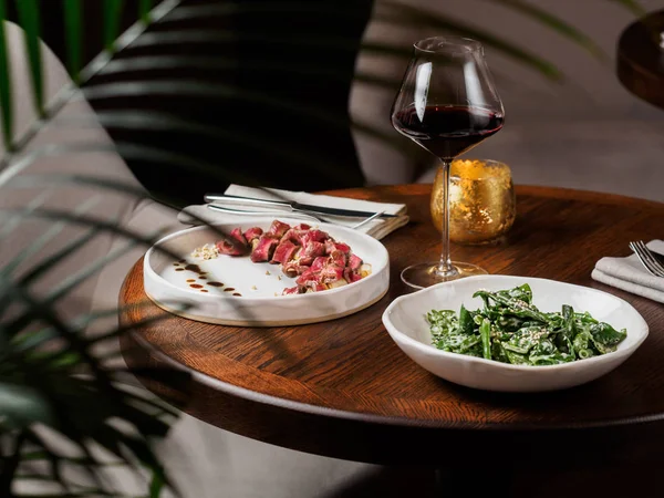 Houten Tafel Met Gesneden Biefstuk Salade Glas Rode Wijn — Stockfoto