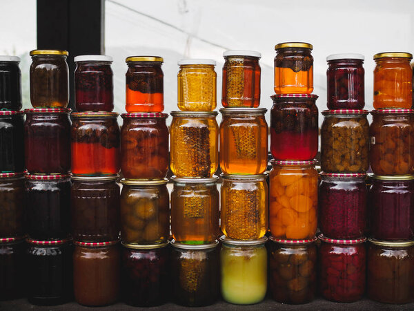 Красочные расчески меда и меда и различные консервы в банках на местном рынке. Армения, Кавказ
