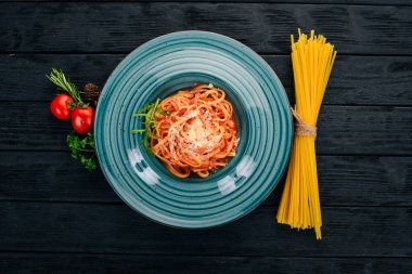 Domatesli makarna makarna. Ahşap bir arka plan üzerinde. İtalyan mutfağı. Üstten Görünüm. Kopya alanı.