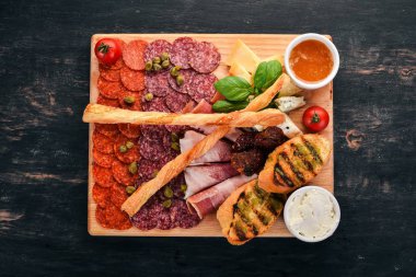 Et kesim ve soğuk aperatifler. İtalyan mutfağı. Ahşap bir arka plan üzerinde. Üstten görünüm. Kopya alanı.