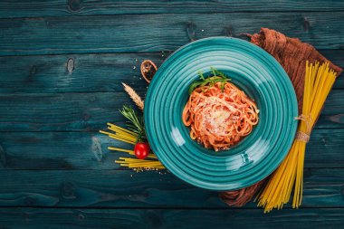 Domatesli makarna makarna. Ahşap bir arka plan üzerinde. İtalyan mutfağı. Üstten Görünüm. Kopya alanı.