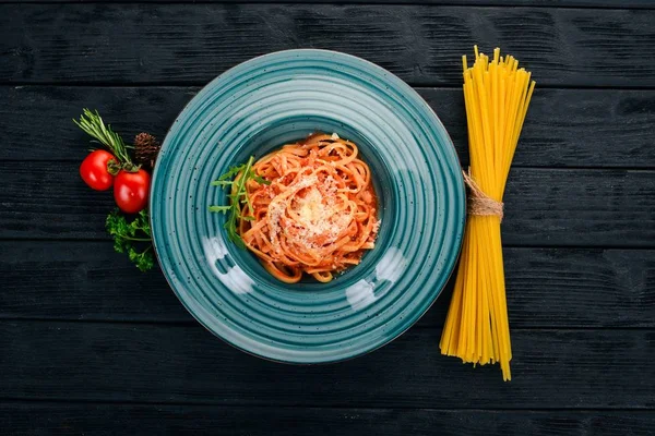 Domatesli makarna makarna. Ahşap bir arka plan üzerinde. İtalyan mutfağı. Üstten Görünüm. Kopya alanı.