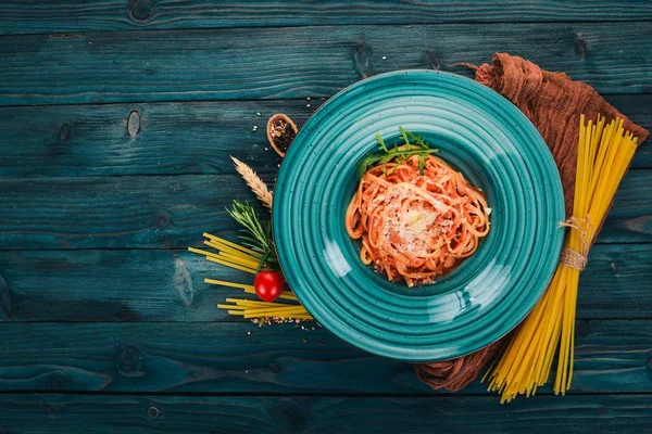 Domatesli makarna makarna. Ahşap bir arka plan üzerinde. İtalyan mutfağı. Üstten Görünüm. Kopya alanı.