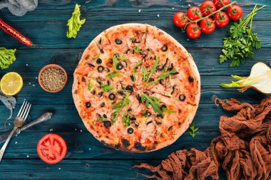 Pizza capricciosa. Mozzarella peyniri, jambon, mantar, zeytin. Üstten Görünüm. Ahşap bir arka plan üzerinde. Kopya alanı.