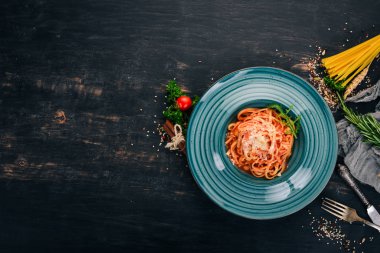 Domatesli makarna makarna. Ahşap bir arka plan üzerinde. İtalyan mutfağı. Üstten Görünüm. Kopya alanı.