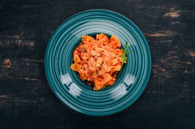 Farfalle makarna domates ve parmesan peyniri. Ahşap bir arka plan üzerinde. İtalyan mutfağı. Üstten Görünüm. Kopya alanı.