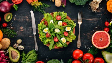 Salata, ıspanak ve bıldırcın ahşap bir arka plan üzerinde yumurta. Sağlıklı gıda. Üstten Görünüm. Kopya alanı.