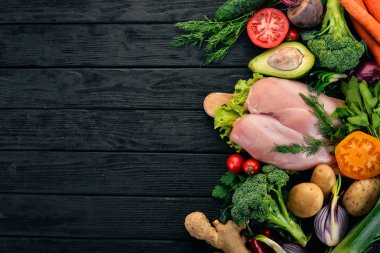 Tavuk göğsü ve taze sebze. Sağlıklı gıda. Siyah ahşap arka plan üzerinde. Üstten Görünüm. Kopya alanı.