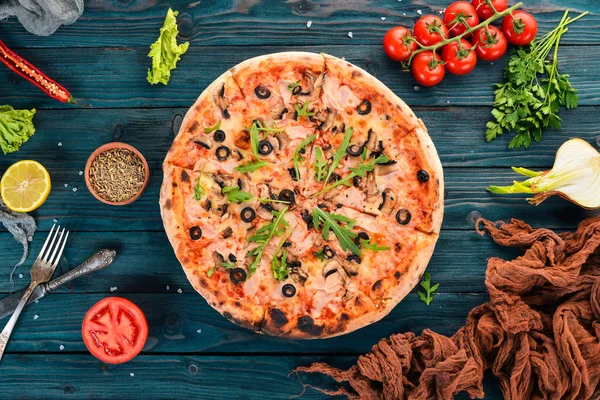 Pizza capricciosa. Mozzarella peyniri, jambon, mantar, zeytin. Üstten Görünüm. Ahşap bir arka plan üzerinde. Kopya alanı.