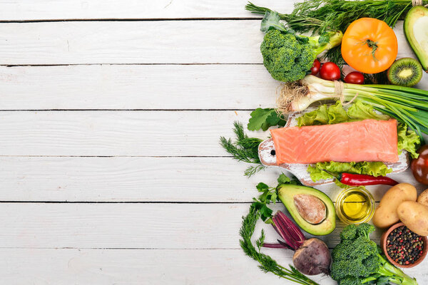 Рыба и свежие овощи. Здоровое питание. На белом деревянном фоне. Здоровое питание. Вид сверху. Копирование пространства
.