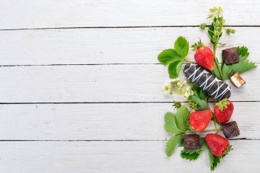 Çilek tatlılar. Beyaz ahşap zemin üzerinde. Üstten görünüm. Kopya alanı.