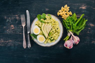 Makarna ıspanak, avokado ve haşlanmış yumurta. Ahşap bir arka plan üzerinde. Üstten görünüm. Kopya alanı.