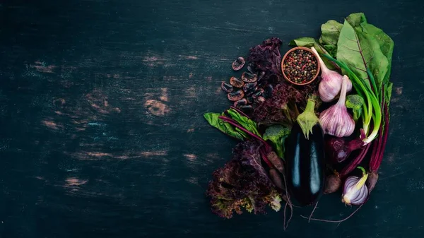 Purple food. Fresh vegetables and berries. On a wooden background. Top view. Copy space.