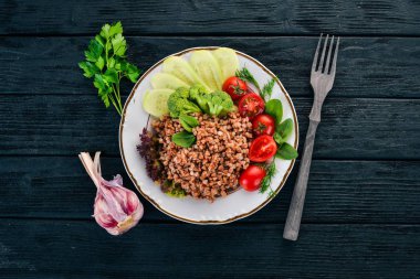 Karabuğday salatalık, brokoli ve domates ile. Ahşap bir arka plan üzerinde. Üstten görünüm. Kopya alanı.