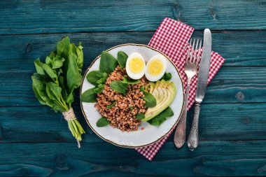 Karabuğday avokado, ıspanak ve haşlanmış yumurta. Ahşap bir arka plan üzerinde. Üstten görünüm. Kopya alanı.