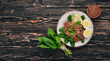 Karabuğday avokado, ıspanak ve haşlanmış yumurta. Ahşap bir arka plan üzerinde. Üstten görünüm. Kopya alanı.