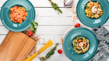 Tabak pişmiş macunlar kümesi. Ahşap bir arka plan üzerinde. İtalyan mutfağı. Üstten Görünüm. Kopya alanı.