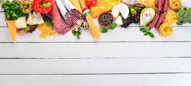 İtalyan sosisi, peynir ve sebze. Beyaz ahşap zemin üzerinde. Üstten görünüm. Kopya alanı.