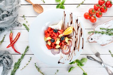 Brie peyniri ile Yunan sebze salatası. Ahşap bir arka plan üzerinde. Üstten görünüm. Kopya alanı.