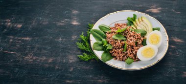 Karabuğday avokado, ıspanak ve haşlanmış yumurta. Ahşap bir arka plan üzerinde. Üstten görünüm. Kopya alanı.