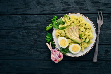 Makarna ıspanak, avokado ve haşlanmış yumurta. Ahşap bir arka plan üzerinde. Üstten görünüm. Kopya alanı.
